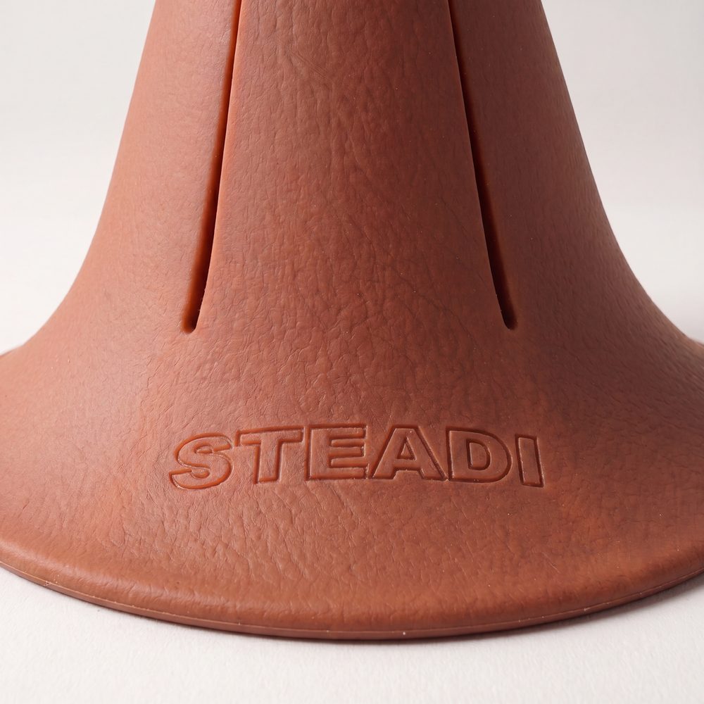 A macro photograph of the flared base of a terracotta Steadi, showing the moulded STEADI mark.